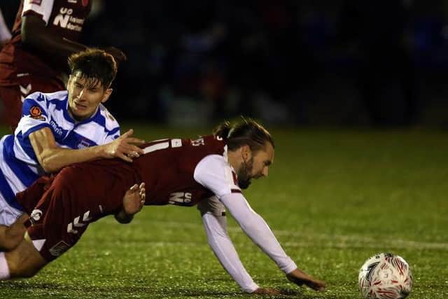 Ricky Holmes is wrestled to the ground.