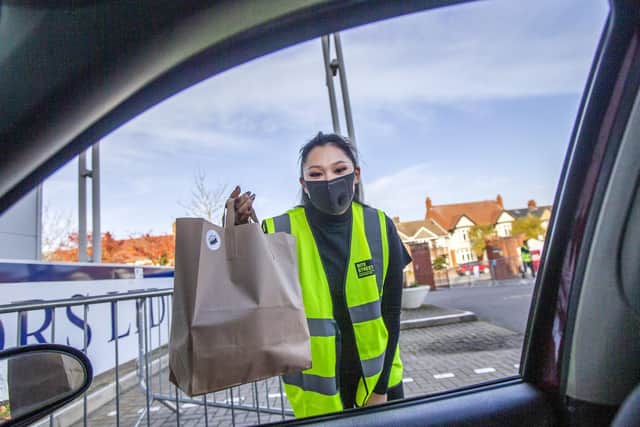 Runner Sasha Greaves pictured at Northamptonshire Cricket Ground, at Wantage Road, handing a customer their takeaway through their car window. Pictures by Kirsty Edmonds.