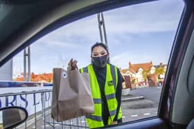 Runner Sasha Greaves pictured at Northamptonshire Cricket Ground, at Wantage Road, handing a customer their takeaway through their car window. Pictures by Kirsty Edmonds.