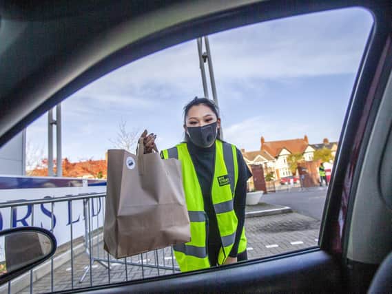 Runner Sasha Greaves pictured at Northamptonshire Cricket Ground, at Wantage Road, handing a customer their takeaway through their car window. Pictures by Kirsty Edmonds.