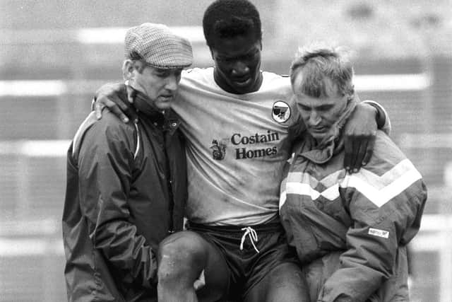 Denis Casey (right) and Jimmy Goodfellow help Terry Angus off the pitch after he suffered an injury