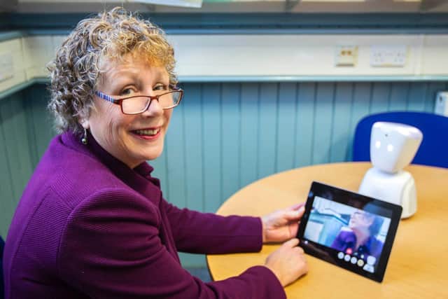 Headteacher Cath Kitchen pictured with the robot in her classroom.