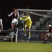Cian Bolger rises highest to head home the Cobblers' winning goal (Picture: Pete Norton)