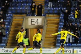 Oxford United's Olamide Shodipo celebrates with team-mates Marcus McGuane and Sean Clare after scoring his side's second goal against the Cobblers