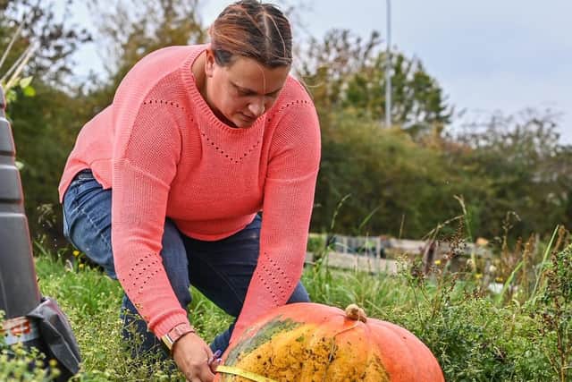 Donna pictured measuring her homegrown pumpkins