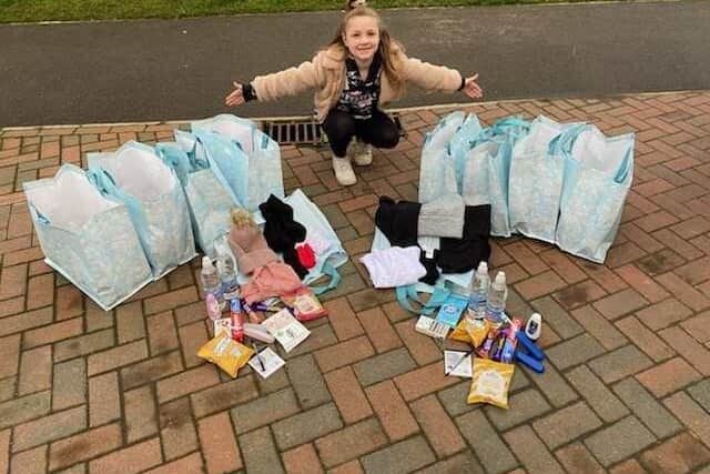 Isla pictured with her care packages, which she fundraised for herself.