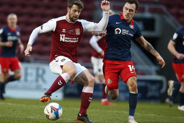 Cobblers midfielder Jack Sowerby is watched closely by Sunderland's Josh Scowen