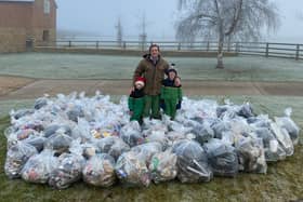 Joe Adams with his children Jessica, seven, (left) and Henry, eight, who helped him sort the bags of rubbish collected from the B4039 outside Daventry