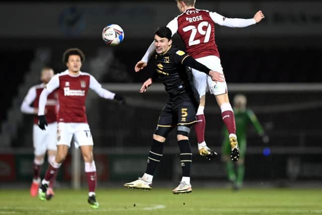 Danny Rose wins this aerial battle with MK Dons defender Regan Poole