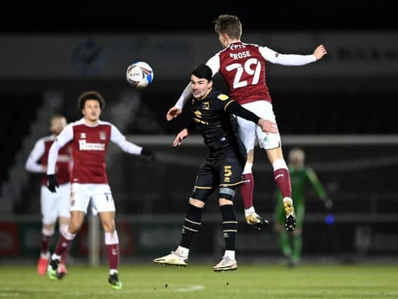 Danny Rose wins this aerial battle with MK Dons defender Regan Poole
