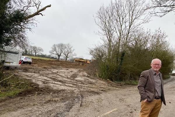 Cllr David Sims at the site last week, which has now had more caravans pulled on to it.