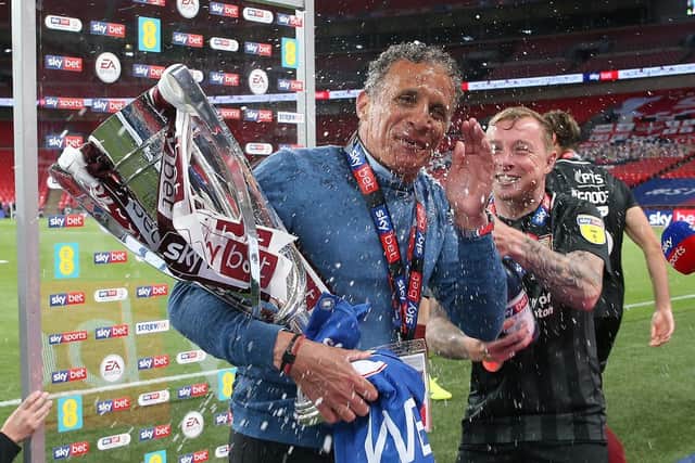 Keith Curle gets the Champagne treatment from Nicky Adams following the Cobblers' Wembley win over Exeter City in June