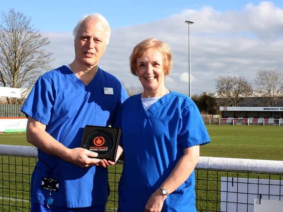 Dr Philip Stevens and his wife Denise show off their Vanarama National League North Volunteers of the Month award for January after their efforts at Brackley Town. Picture courtesy of Brackley Town FC