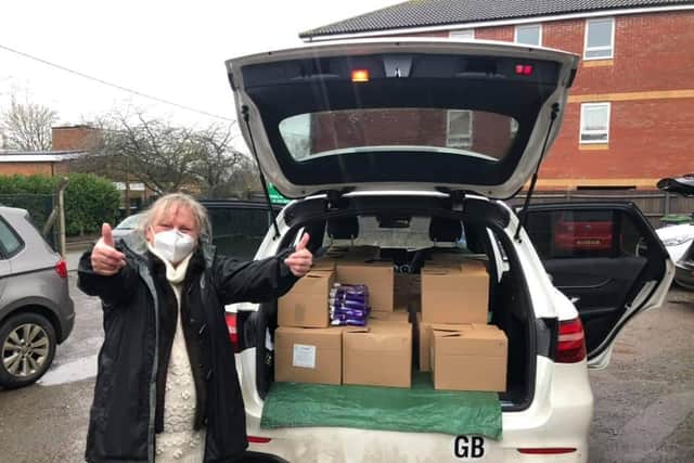 A happy volunteer with a car-full of food boxes to be delivered