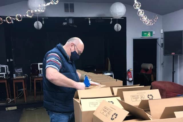 A TowFood volunteer packs up boxes with surplus food