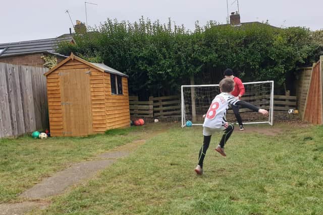 Josh taking on his goal scoring challenge against his dad.