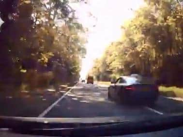 Speeding car was caught on a dashcam overtakes following an ambulance on the wrong side of the road