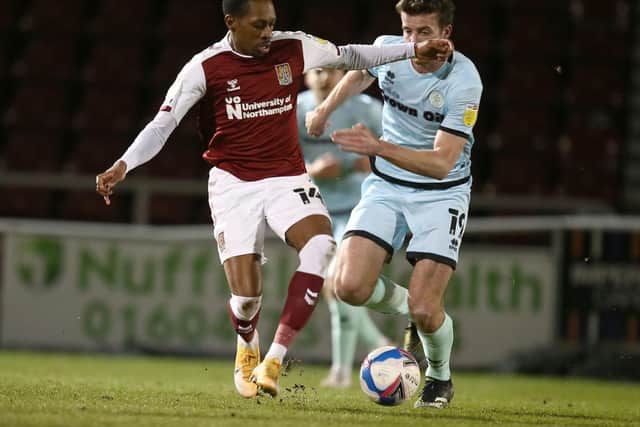 Cobblers winger Mickel Miller holds off the challenge of Rochdale's Connor O'Shaugnessy