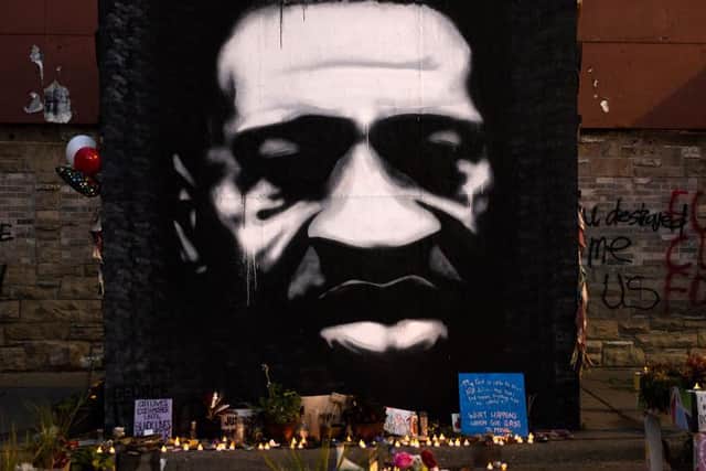 LED candles are placed beneath a portrait of George Floyd during a birthday celebration for him at a memorial site known as "George Floyd Square" on October 14, 2020 / Getty Images