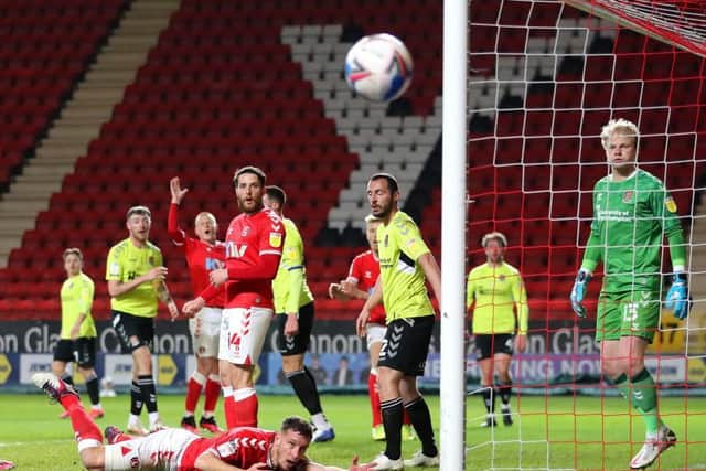 Chartlon's Jason Pierce watches his header flash wide of the Cobblers' goal