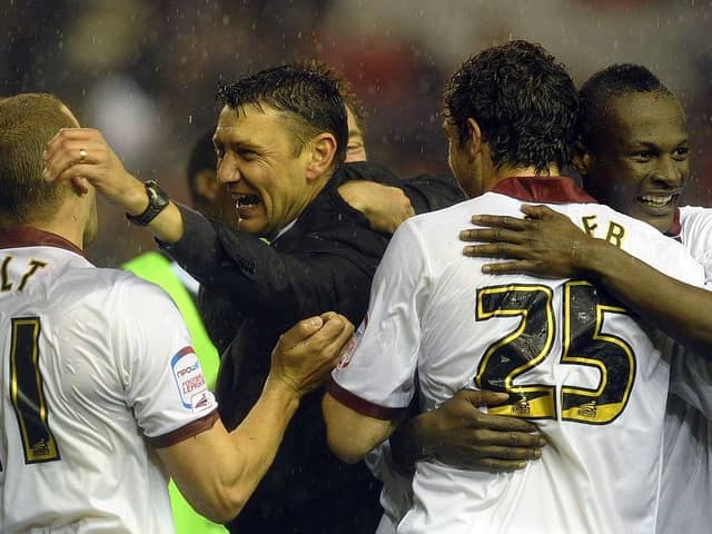 Cobblers boss Ian Sampson celebrates the win at Anfield with Andy Holt, Ben Tozer and Abdul Osman