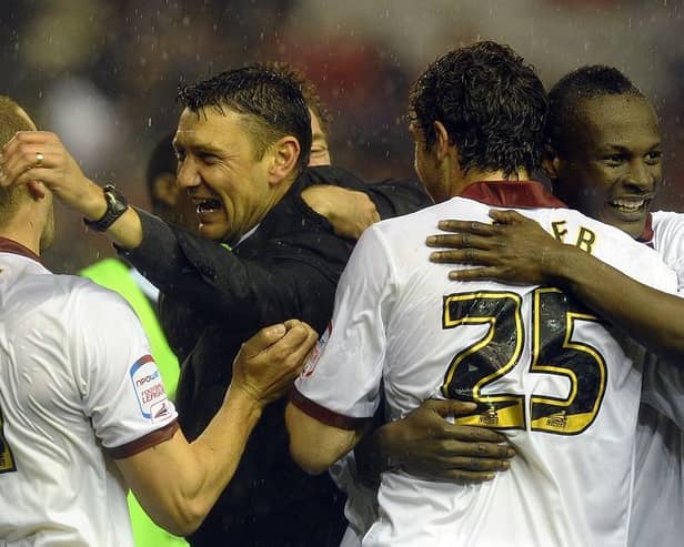 Cobblers boss Ian Sampson celebrates the win at Anfield with Andy Holt, Ben Tozer and Abdul Osman