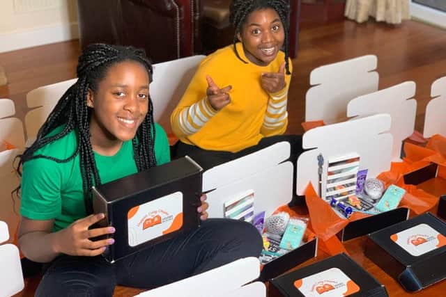Sisters Kisten and Aiyven Mbawa with their monthly book subscription boxes.