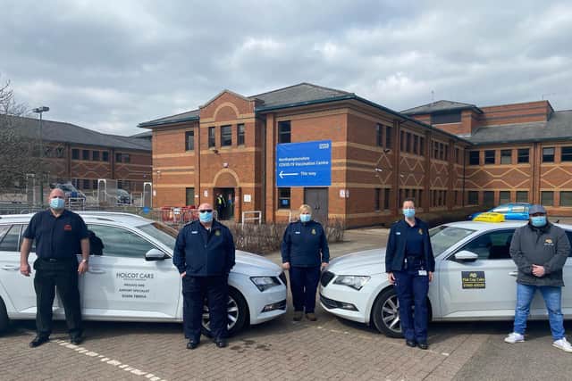 Nick Metaxas (far left), of Holcot Cars, and Freddie Fudge (far right), of Flat Cap Cabs, with three first responders at the mass vaccination centre at Moulton Park, Northampton