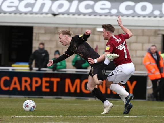 Sam Hoskins pulls back Mansfield's Harry Charsley to concede a penalty in the 10th minute of the Cobblers' 2-1 defeat at the PTS Academy Stadium. The Town man was sent off for the challenge (Picture: Pete Norton)