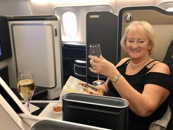 Sally Abel enjoys a glass of bubbly on the flight back to Heathrow