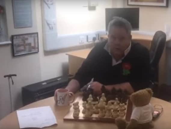 Scene one of the music video features Mark in his office with a chess board and a teddy bear.