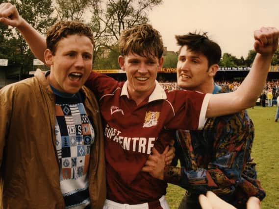 Cobblers goal hero Pat Gavin celebrates with two quick-off-the-mark pitch invaders at Gay Meadow