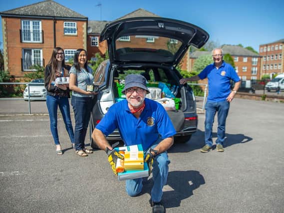 Tim Bedward (front) and Brain May (right) from Northampton Rotary Club making a donation to Esther Veal and her daughter Eleanor Veal at Re:store food bank. Photo: Kirsty Edmonds.