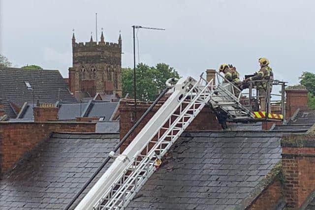 Firefighters pictured on the rooftop this afternoon where the chimney broke.