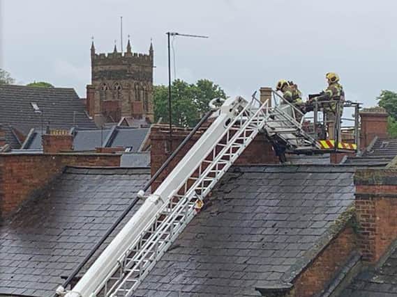 Firefighters pictured on the rooftop this afternoon where the chimney broke.