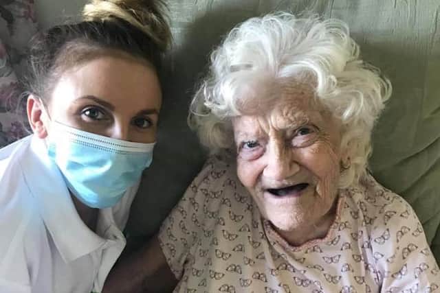 Thelma Sherriff pictured with a care worker on Saturday as she turned 100 years old in isolation.