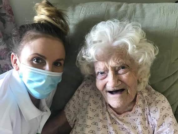 Thelma Sherriff pictured with a care worker on Saturday as she turned 100 years old in isolation.