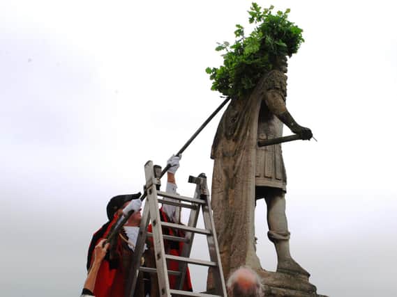 Oak leaves being placed on the statue of Charles II in 2018.