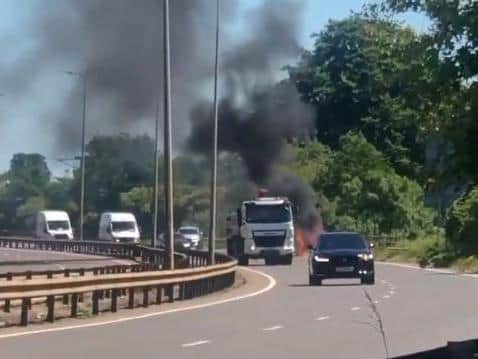 Traffic makes its way past the blazing vehicle