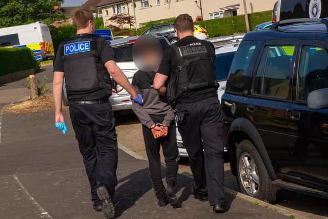 Officers lead a handcuffed suspect away