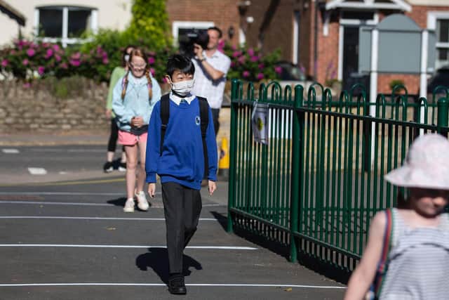 A pupil entering the gates this morning wearing PPE.