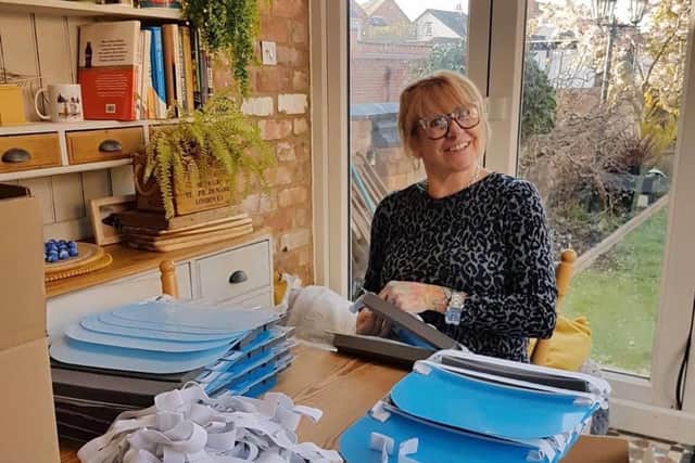 A volunteer pictured at her home putting face shields together for hospitals across the country.