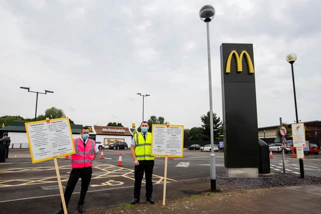 McDonald's staff hold up signs with the menu as the fast food restaurant in Sixfields reopened on Wednesday, June 3. Photo: Leila Coker