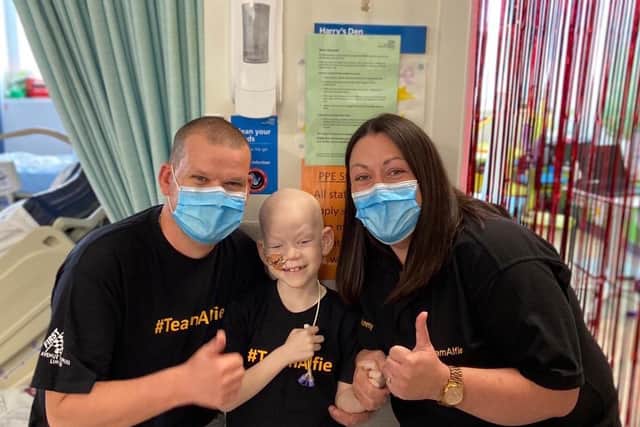Alfie pictured in hospital with his mum and dad after ringing the bell following his last chemotherapy treatment there.