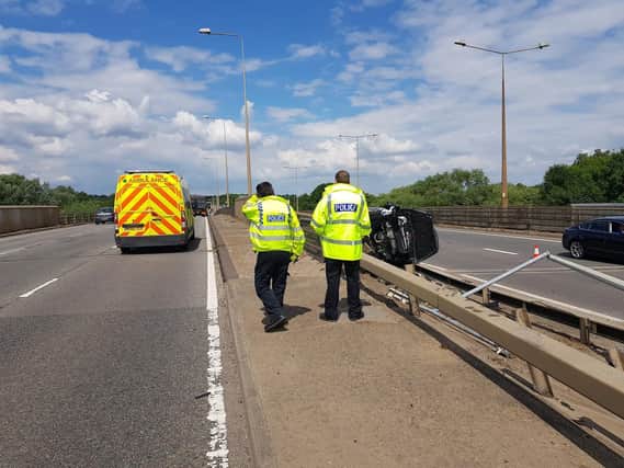 Police survey the wreckage of the Ford Fiesta which collided with the safety barrier on the A45. Photo: Northamptonshire Police