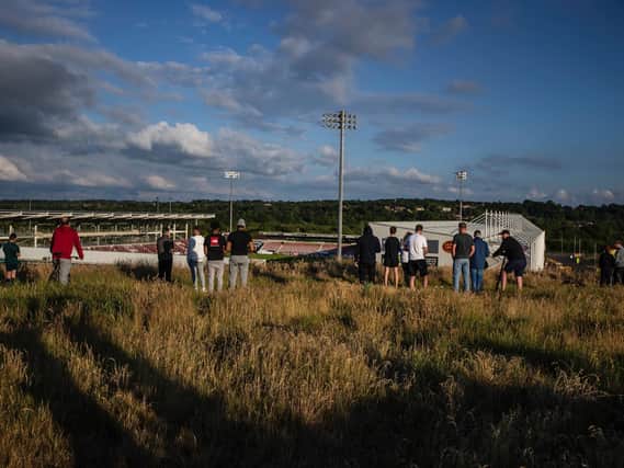 Groups of people have been seen watching the game from the hill that overlooks the stadium. Photo: Kirsty Edmonds.