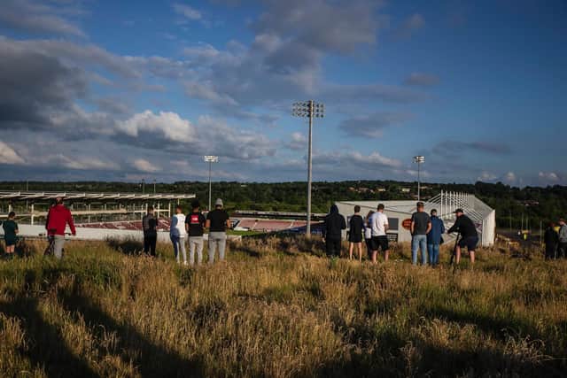 Groups of people have been seen watching the game from the hill that overlooks the stadium. Photo: Kirsty Edmonds.
