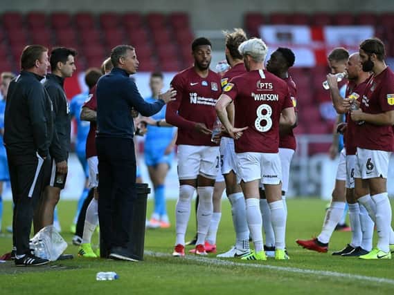 Keith Curle talks to his players during a drinks break in the first leg.