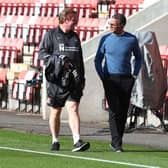 Keith Curle and Ronnie Jepson go for a stroll on the touchline at Whaddon Road.