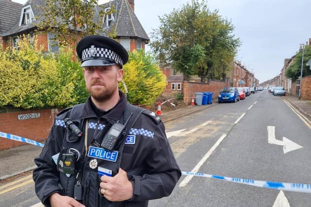 A police officer guards the cordon across Wood Street in Kettering